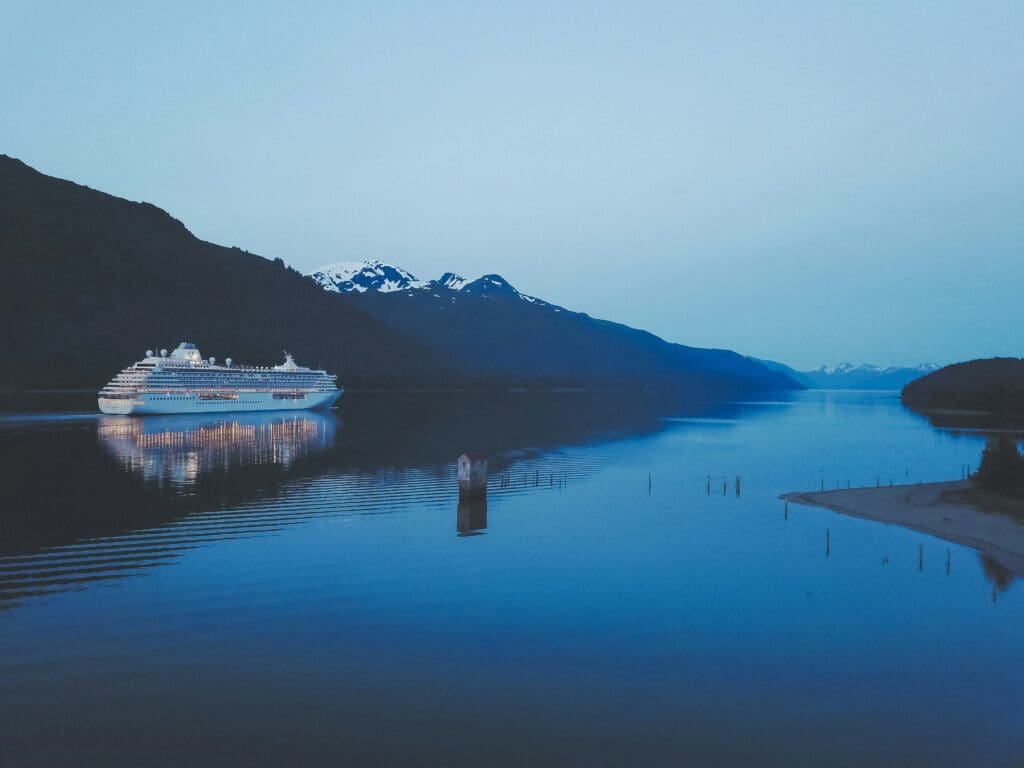 A cruise ship sits in the calm waters of Alaska's Inside Passage